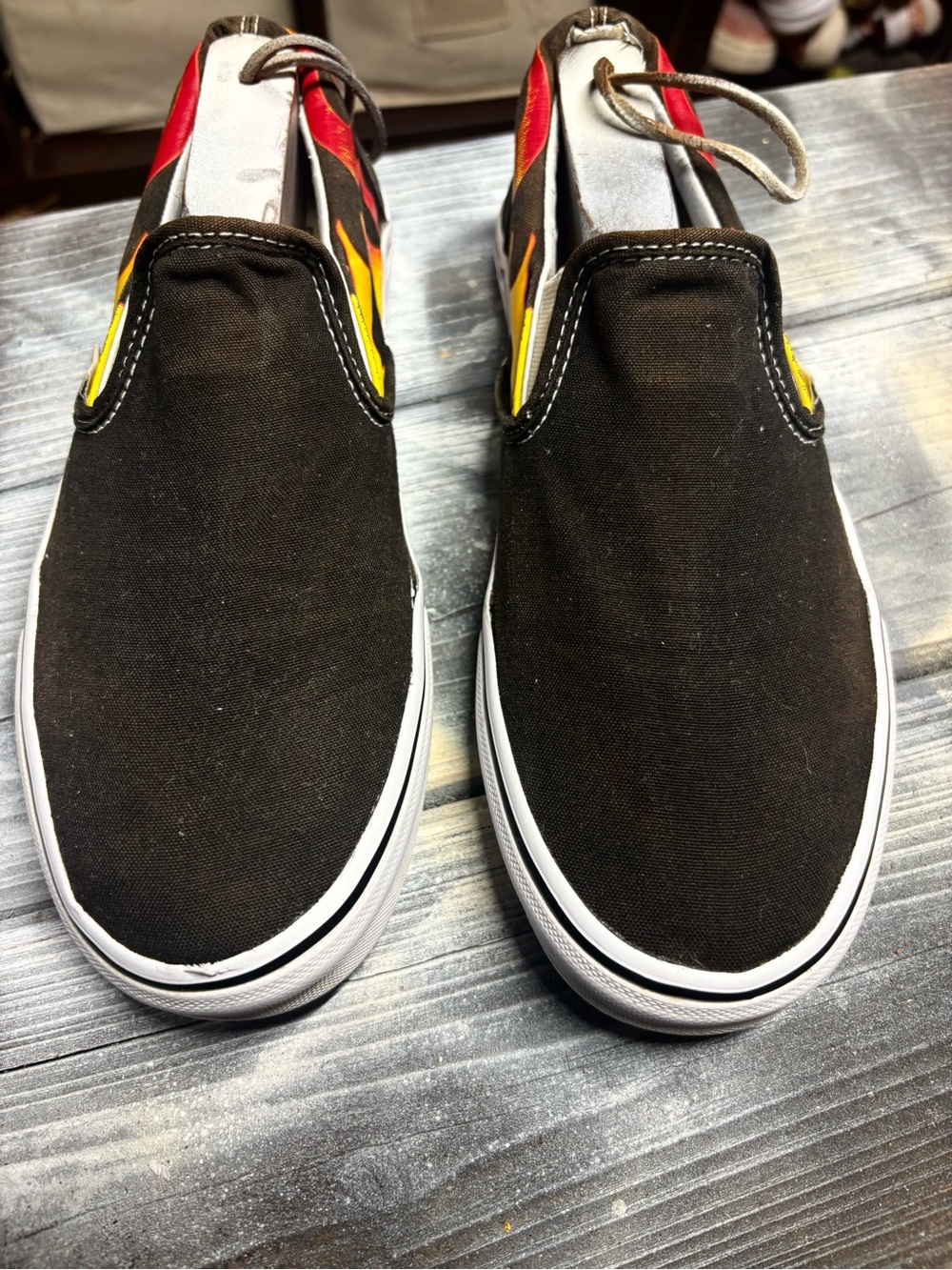 Vans slip on black sneakers with red, yellow, and black flame M 8.5 W10